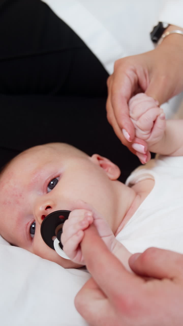 Little child motherhood. Small newborn baby on parents hands. Vertical video