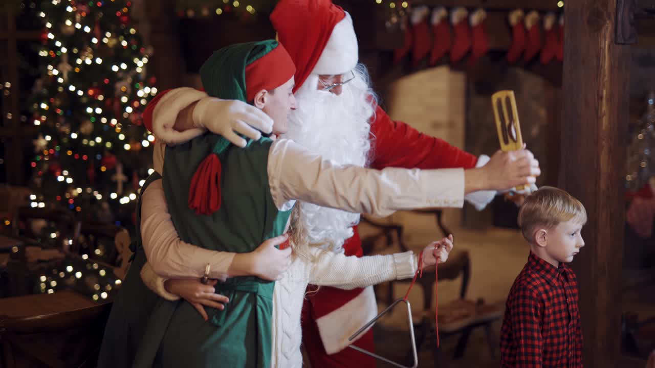 Santa Claus dancing with children. Children having fun with Santa Claus and elves
