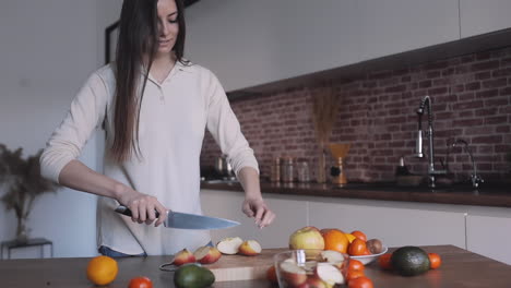 Mujer-Bonita-Joven-Cortando-Manzanas-Y-Frutas