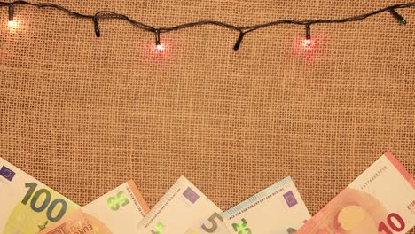 marco de letras de navidad con guirnaldas y euros.