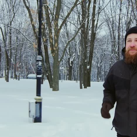 Un-Hombre-Corriendo-En-Un-Parque-Cubierto-De-Nieve