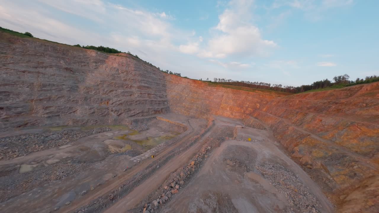 FPV flight above calcite-rich quarry, open pit in rocky terrain