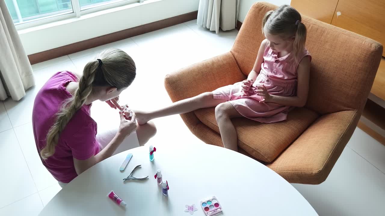 mãe e filha fazendo arte de unhas em casa