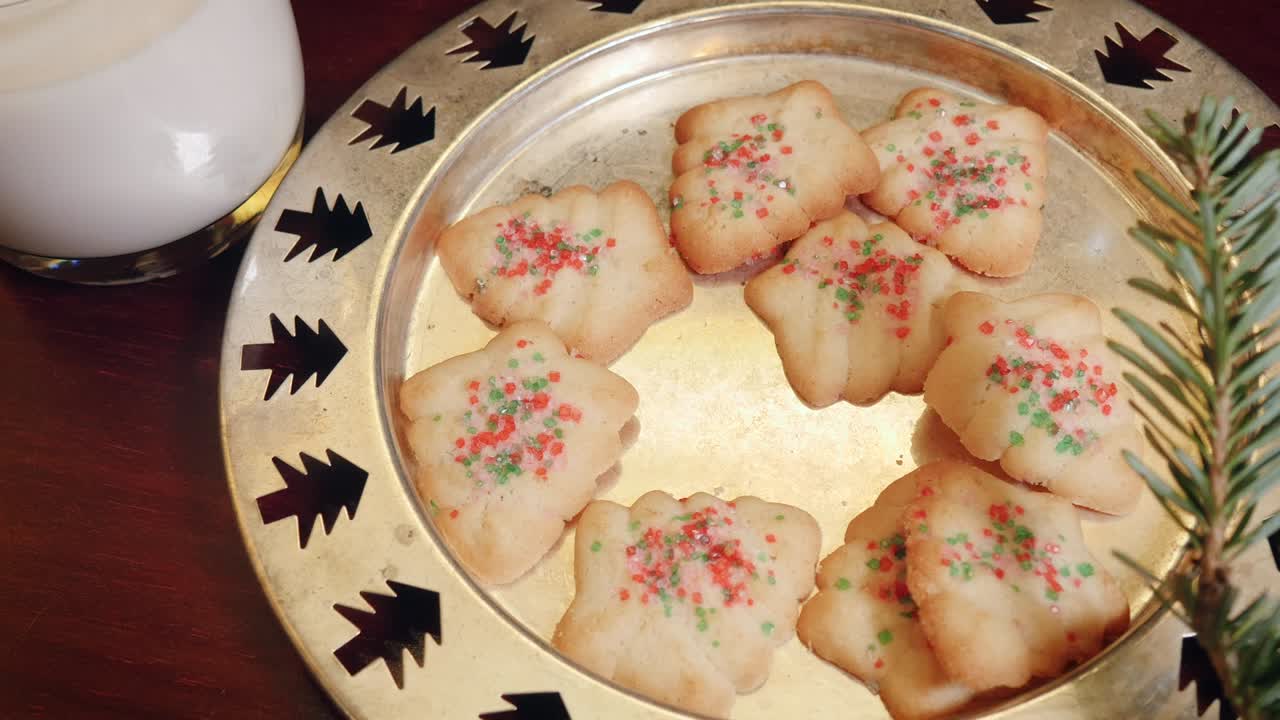 una mujer agarra una galleta de navidad de un plato en 4k