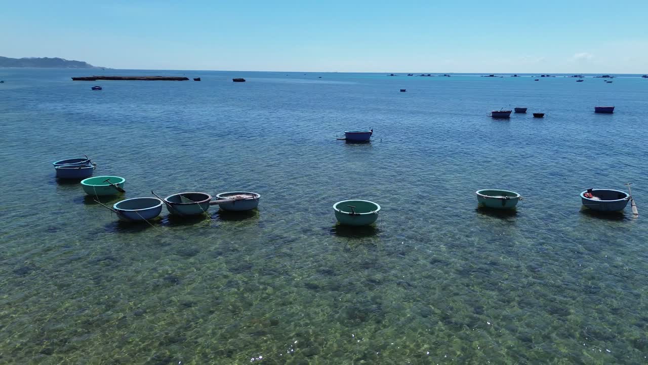 Semi orbit aerial view of traditional circular basket boats floating on clear waters, Phan Rang in Ninh Hải District, Ninh Thuận, Vietnam