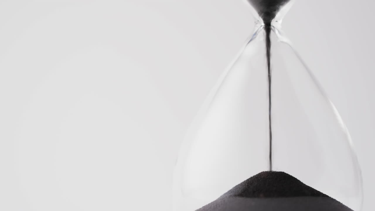 Video of hourglass with sand pouring, copy space on white background