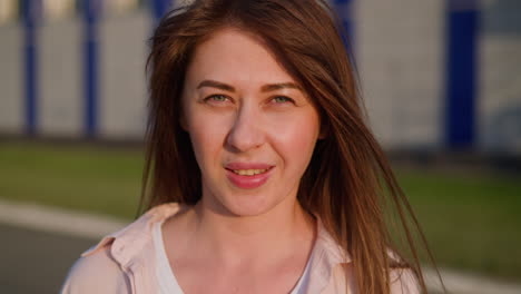 Pretty-redhead-woman-smiles-to-camera-standing-on-street