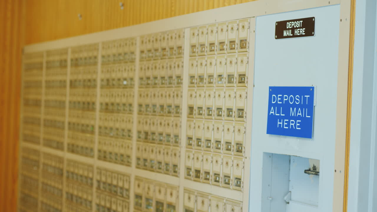 молодая женщина в очках бросает несколько писем в почтовый ящик на почте