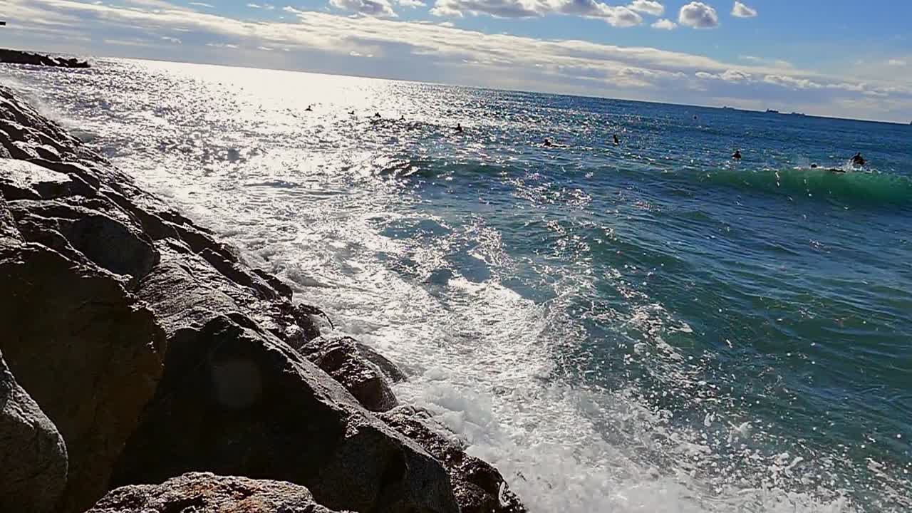 Slow motion (120fps): waves crashing into stone sea barrier in Barcelona, Spain