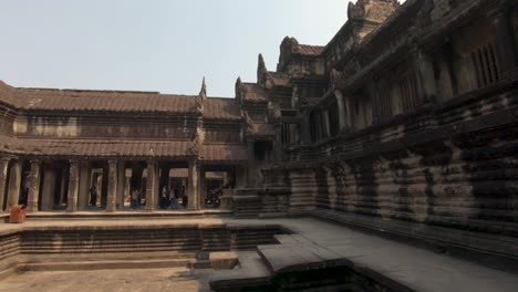 Tourists-visiting-famous-Cambodia-landmark,-the-interior-courtyard-of-Angkor-Wat-Temple