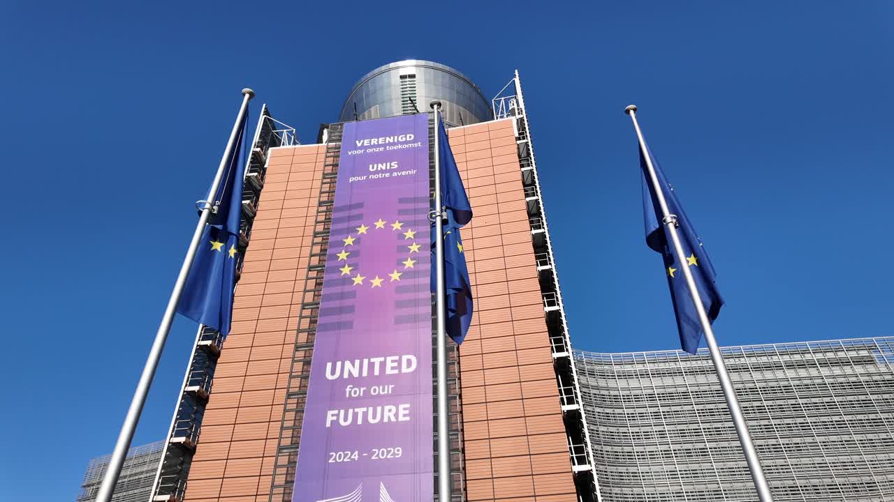 EU flags flutter beside 2024–2029 political message at Berlaymont building