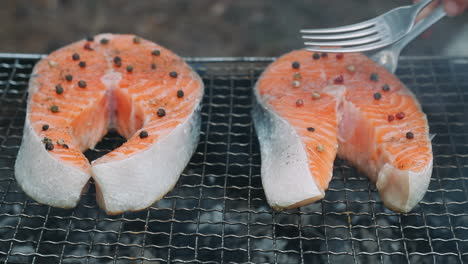 salmón a la parrilla en la parrilla de carbón. cocinero de cerca girando el filete de salmón