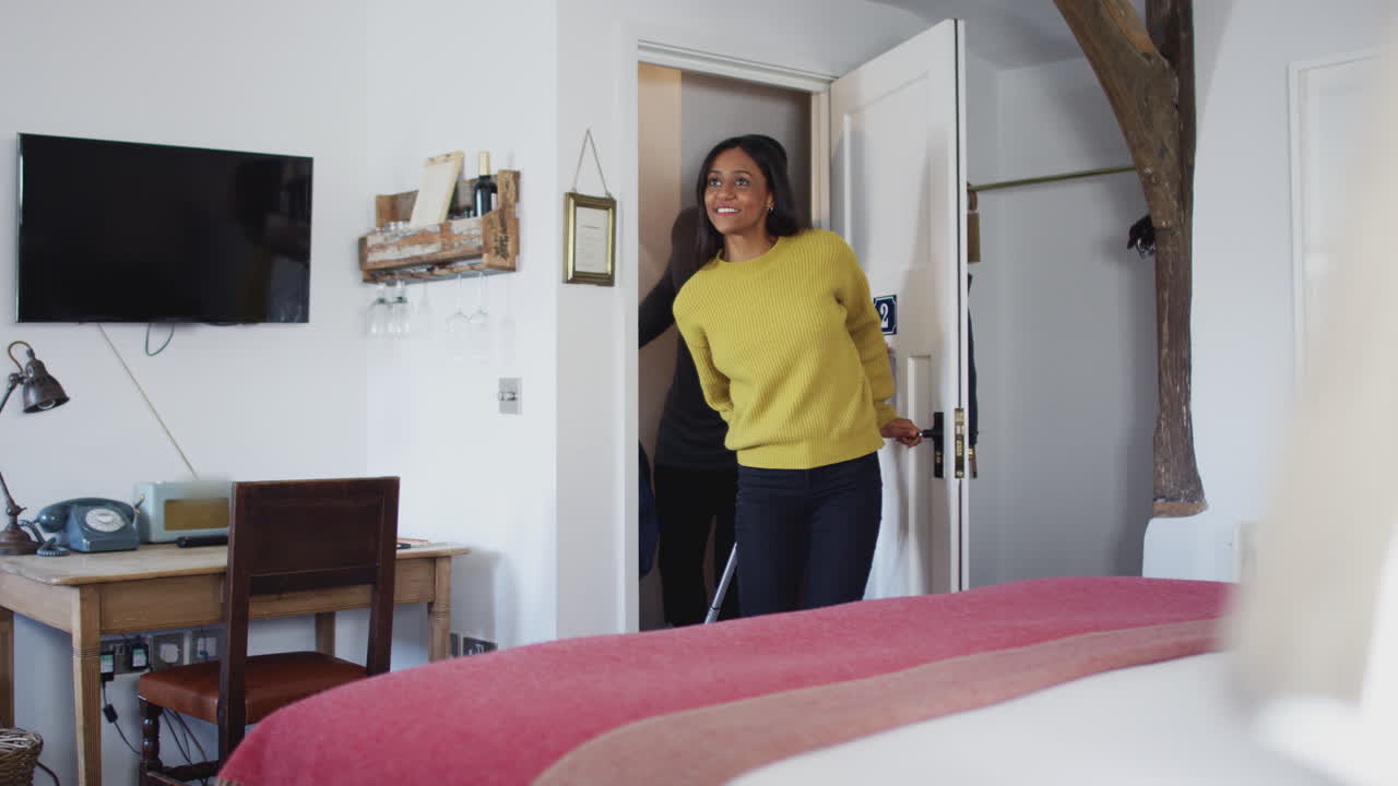 Couple Spending Romantic Weekend Away Opening Door Of Hotel Room And Hugging
