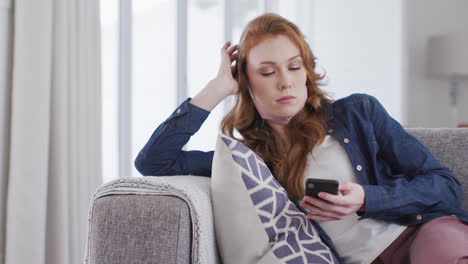 Mujer-Usando-Un-Teléfono-Inteligente-Mientras-Está-Sentada-En-El-Sofá-En-Casa