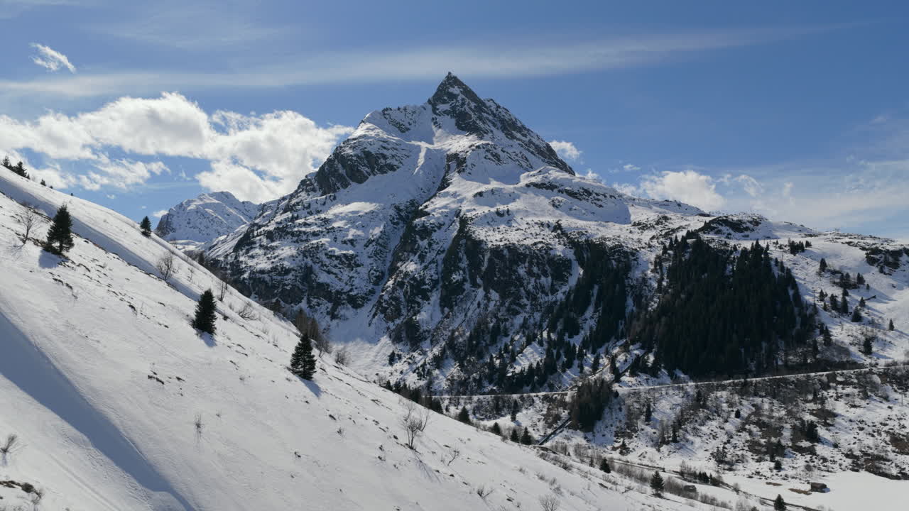 Piste innevate in una catena montuosa alpina in una giornata di sole VISTA AEREA