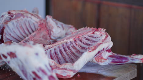butchered lamb carcass split and salted on rustic wooden table, showcasing traditional meat preparation