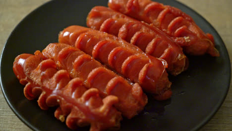 deep-fried-sausage-skewer-on-black-plate