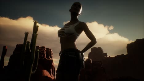 mujer con camisa rasgada de pie junto a un cactus en el desierto al atardecer