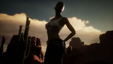 woman in torn shirt standing by cactus in desert at sunset