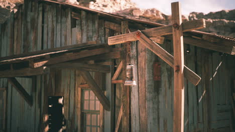 rustic wooden building with a lantern hanging outside in a desert setting