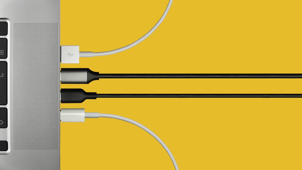 다양한 컴퓨터 케이블이 노트북에 연결되고 있습니다.