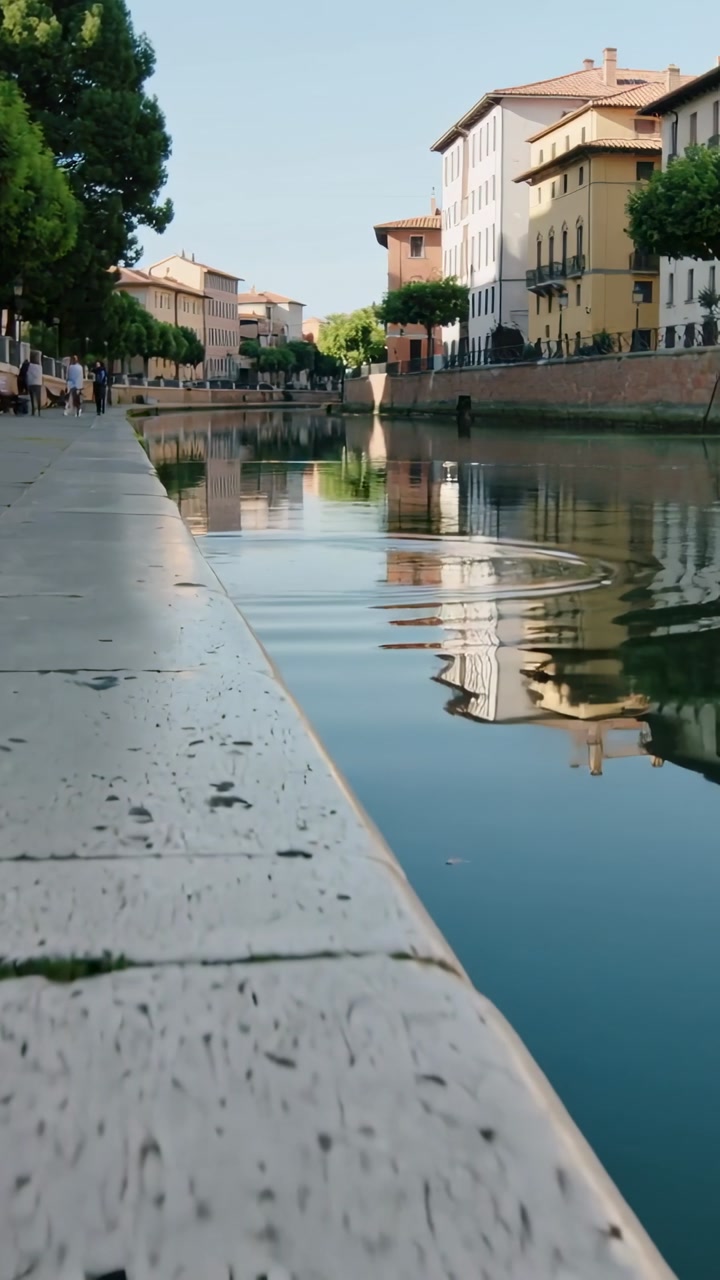 Canal surface reacting to splash, sending ripples distorting reflections for travel storytelling