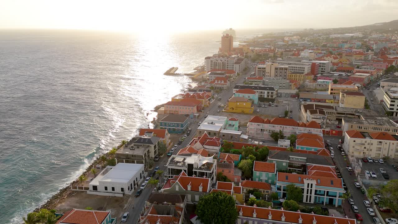 Ripresa aerea ascendente con drone al tramonto di Pietermaai, con l'architettura fronte oceano che risplende di luce calda vicino a Willemstad.