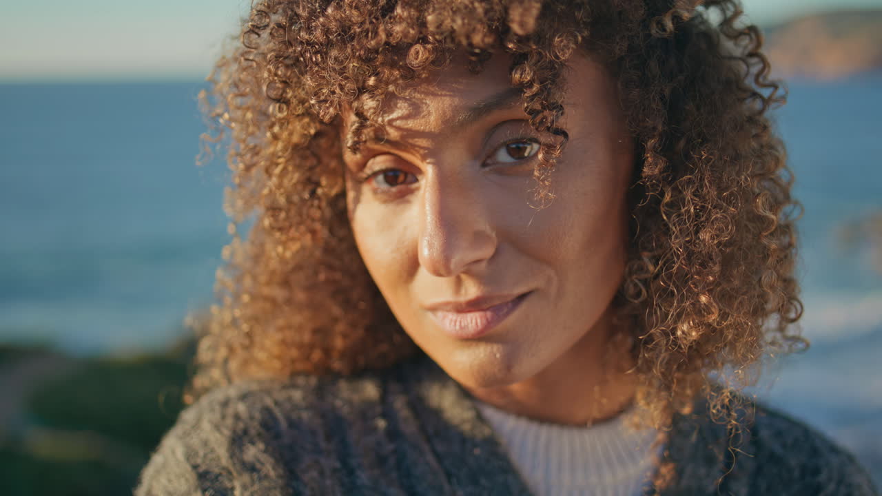 Gentle woman enjoying sunlight at ocean background closeup. Serene girl portrait