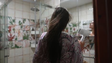 woman drying hair in bathroom