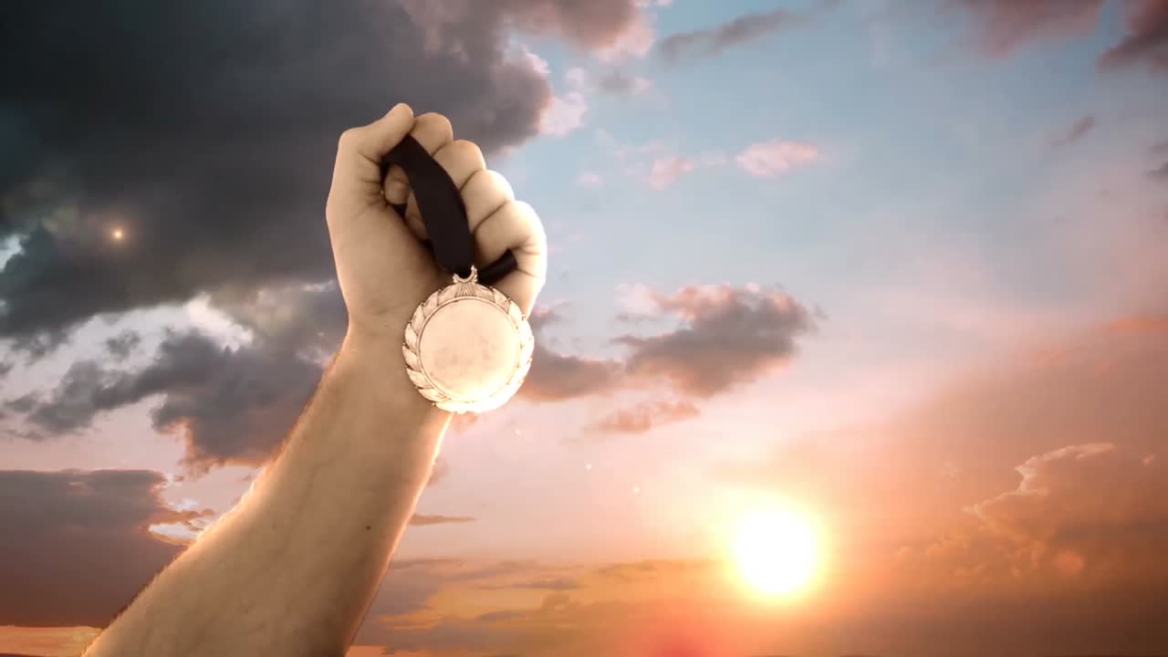 la mano del atleta con la medalla de oro
