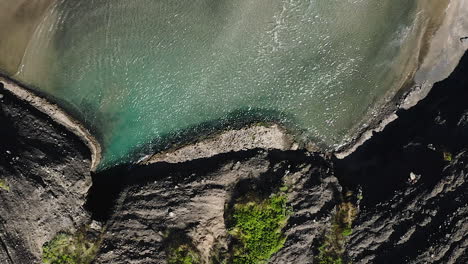 Wind-Verursacht-Wellen-Auf-Der-Oberfläche-Des-Flachen-Türkisfarbenen-Pools-Am-Sandstrand-Von-Piha,-Neuseeland