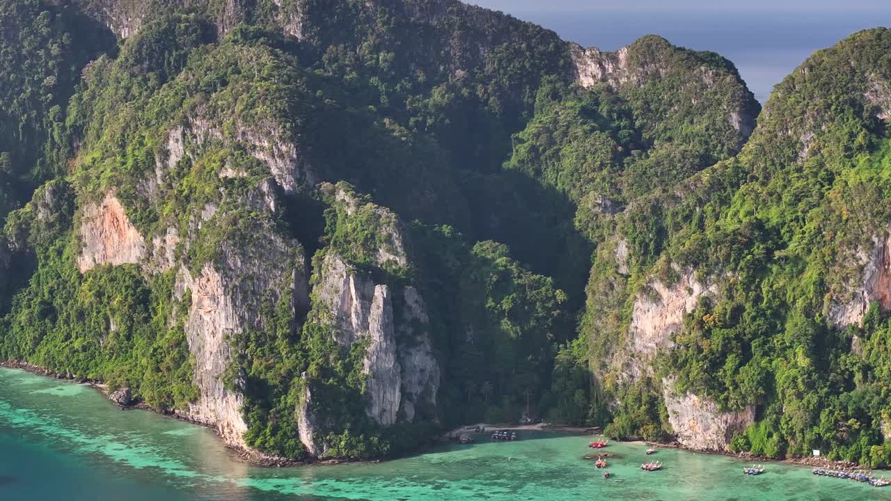 Dramatic rocky cliffs covered in lush green vegetation. Koh Phi Phi Don aerial, Thailand
