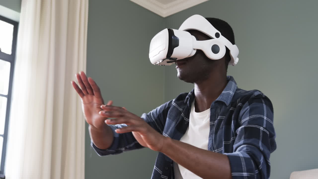 African American man using VR headset at home, exploring virtual reality world