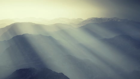 mountain landscape with sunlight rays piercing through misty atmosphere