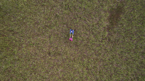 una pareja joven tomándose de la mano en un campo.