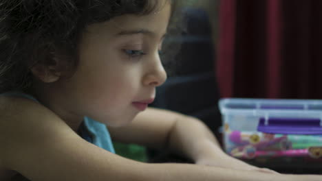 close up portrait of a young female child coloring with crayon
