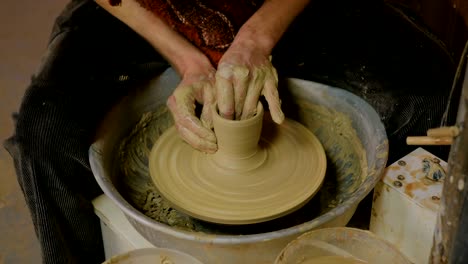 professional male potter making mug in pottery workshop