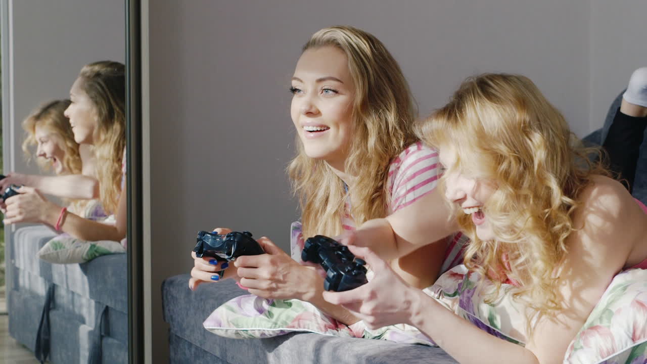 컴퓨터 콘솔에서 놀고 있는 두 명의 젊은 여성 친구