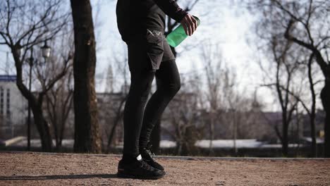 male legs in black tight compression leggins walking in park. sport and recreation.