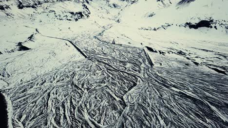 drone showing beautiful patterns in the landscape below, on snowy conditions