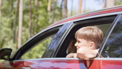 video of boy enjoying the road with hands on the road breeze