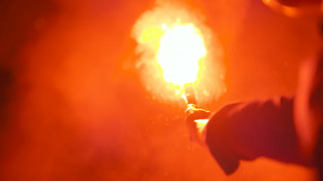 close up of a burning signal flare held by a man