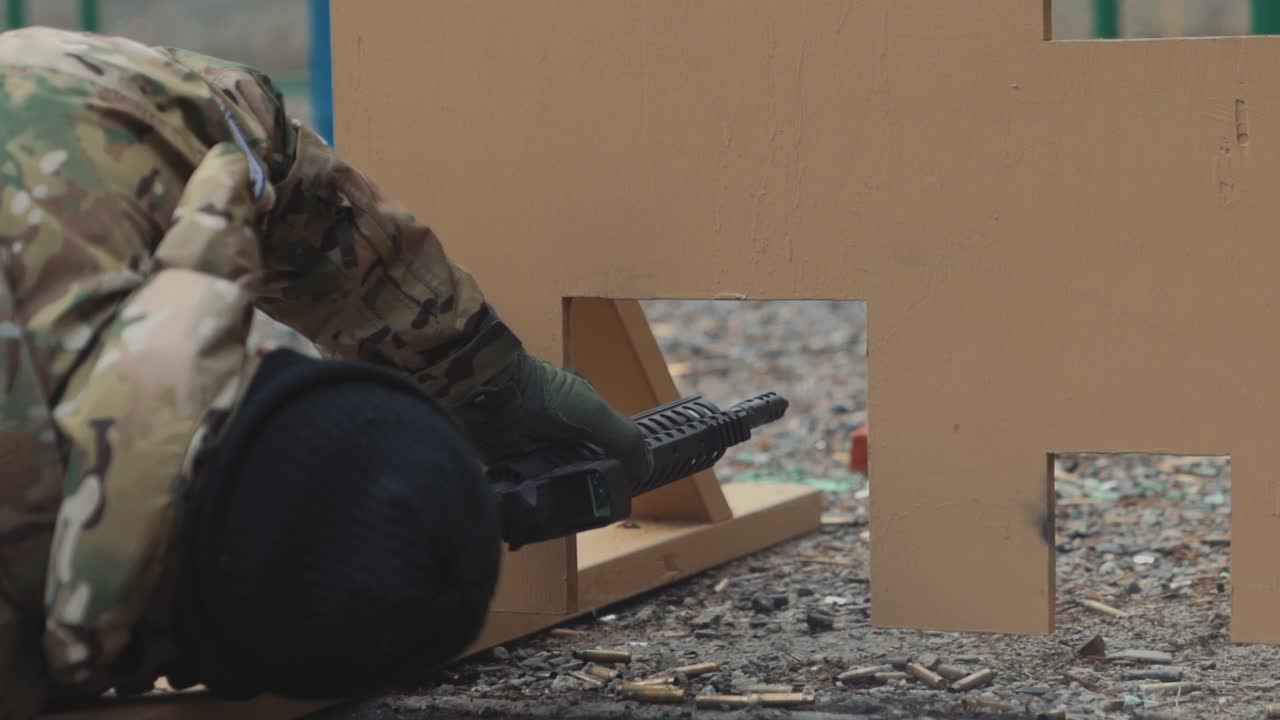Man Laying on the Ground Shooting AR 15 Rifle from Prone Position