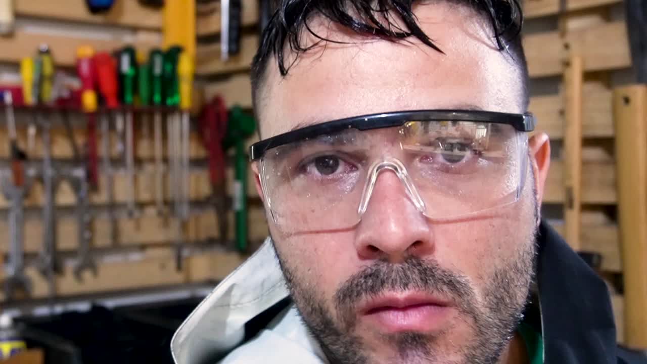 Man is pointing a electrict screwdriver to the camera