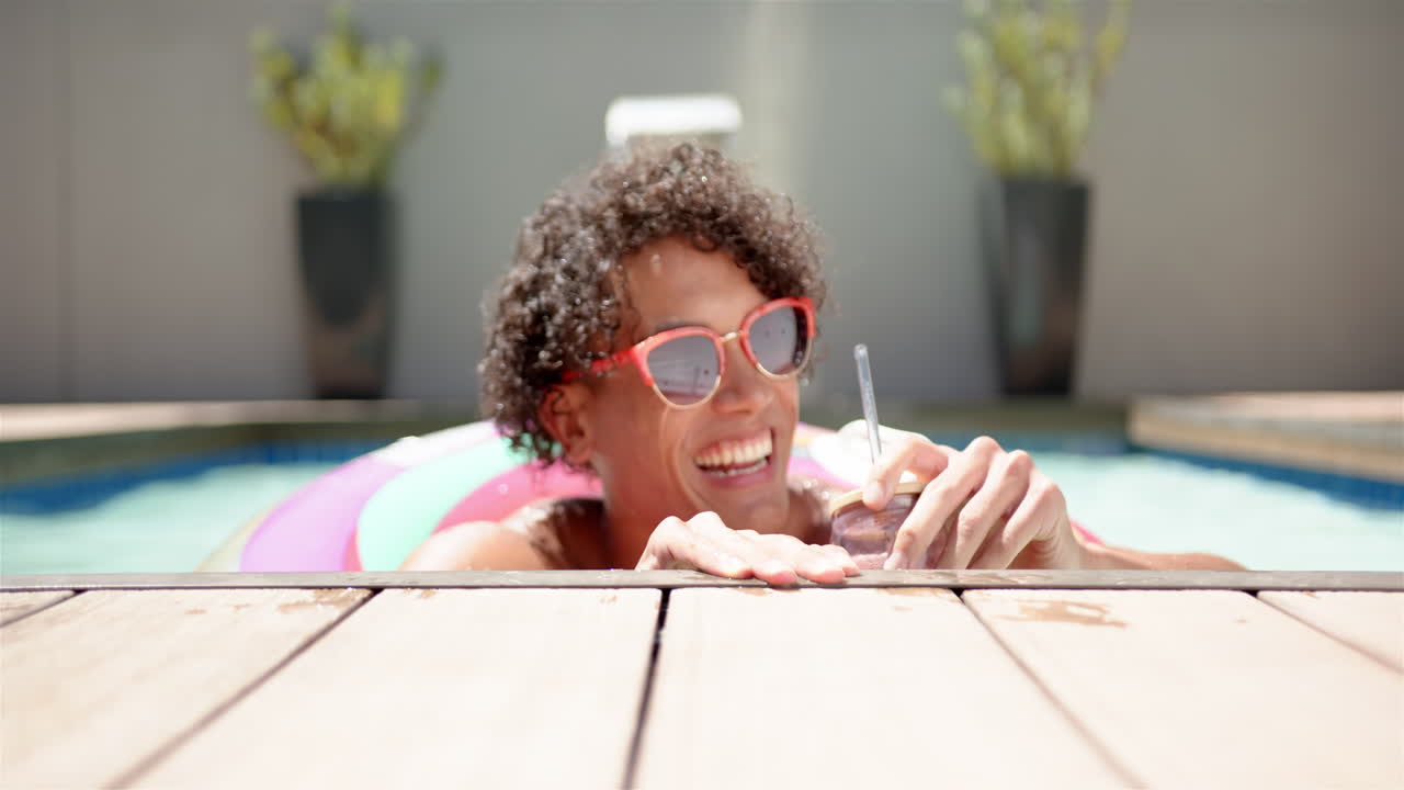A young biracial man relaxes in a pool at home
