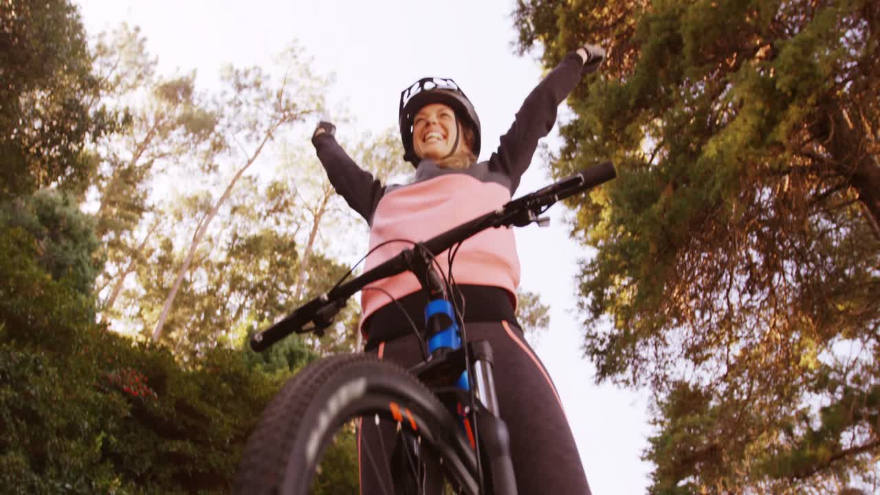 motociclista de montaña excitada con los brazos extendidos