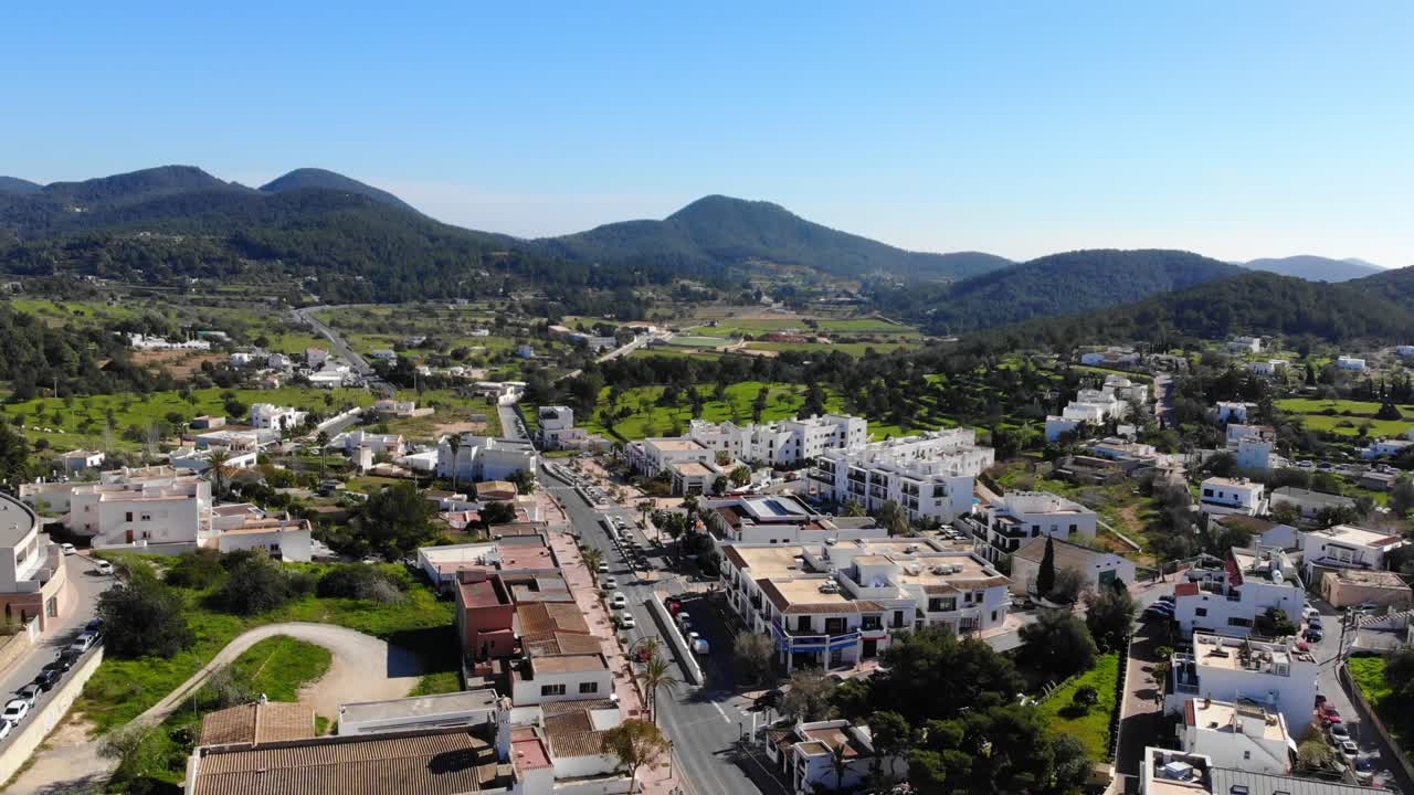 drone de ibiza se eleva con vistas a colinas, campos y casas