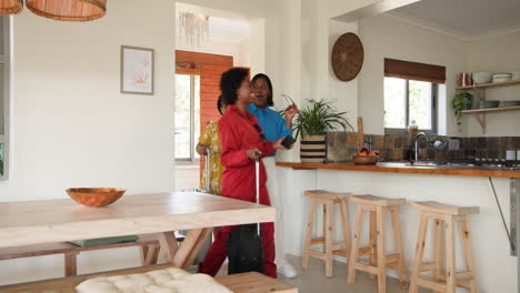 entering home, three female friends carrying luggage and chatting happily