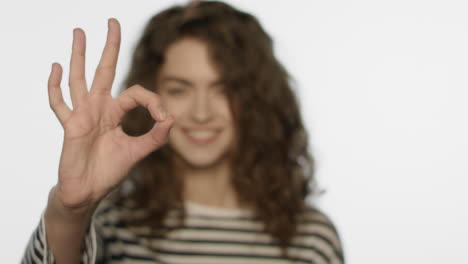 chica sonriente mostrando la mano ok. retrato de mujer sonriente mostrando el gesto ok