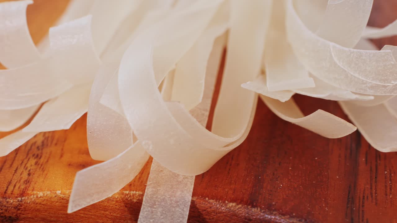 Raw Rice Noodles on a Wooden Cutting Board